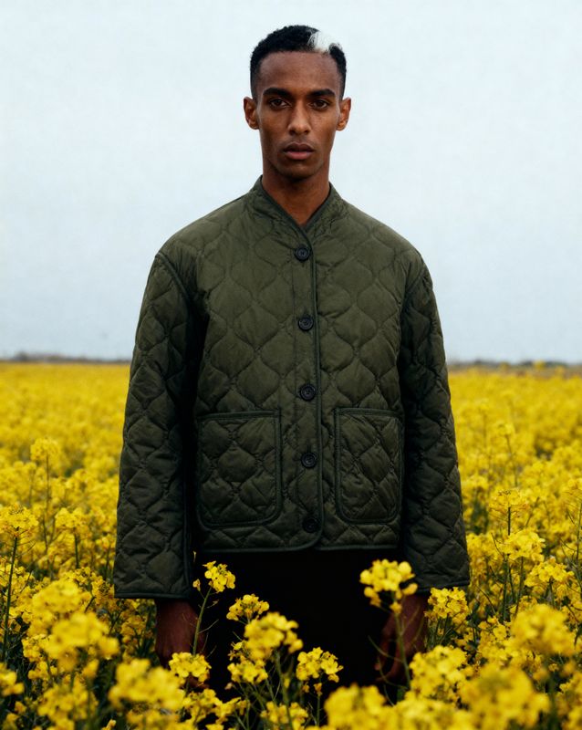 a man standing in a field of yellow flowers