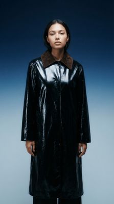 a woman in a black coat with a brown collar