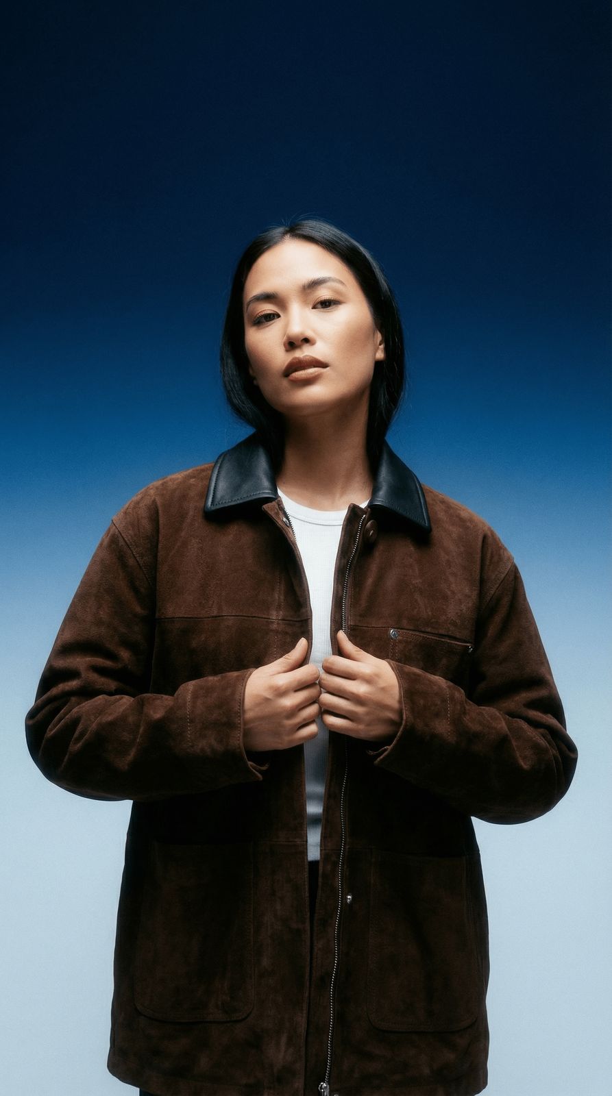 a woman in a brown jacket and white shirt