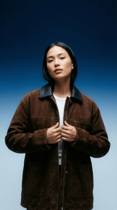 a woman in a brown jacket and white shirt