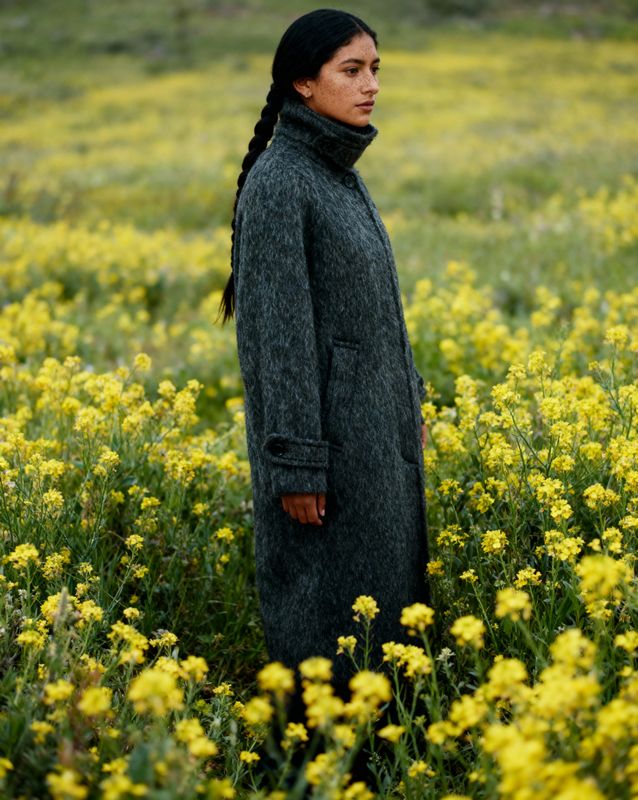 a woman standing in a field of yellow flowers