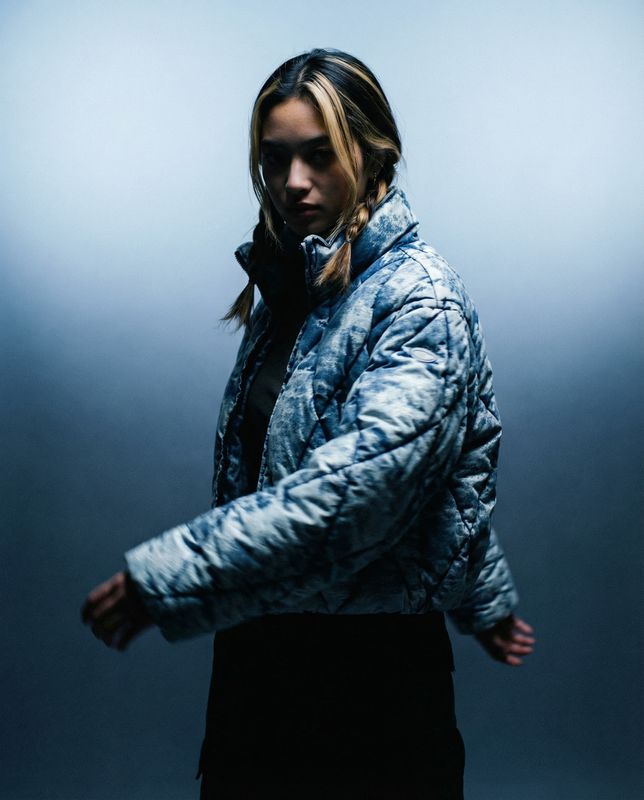 a woman in a blue jacket and black skirt