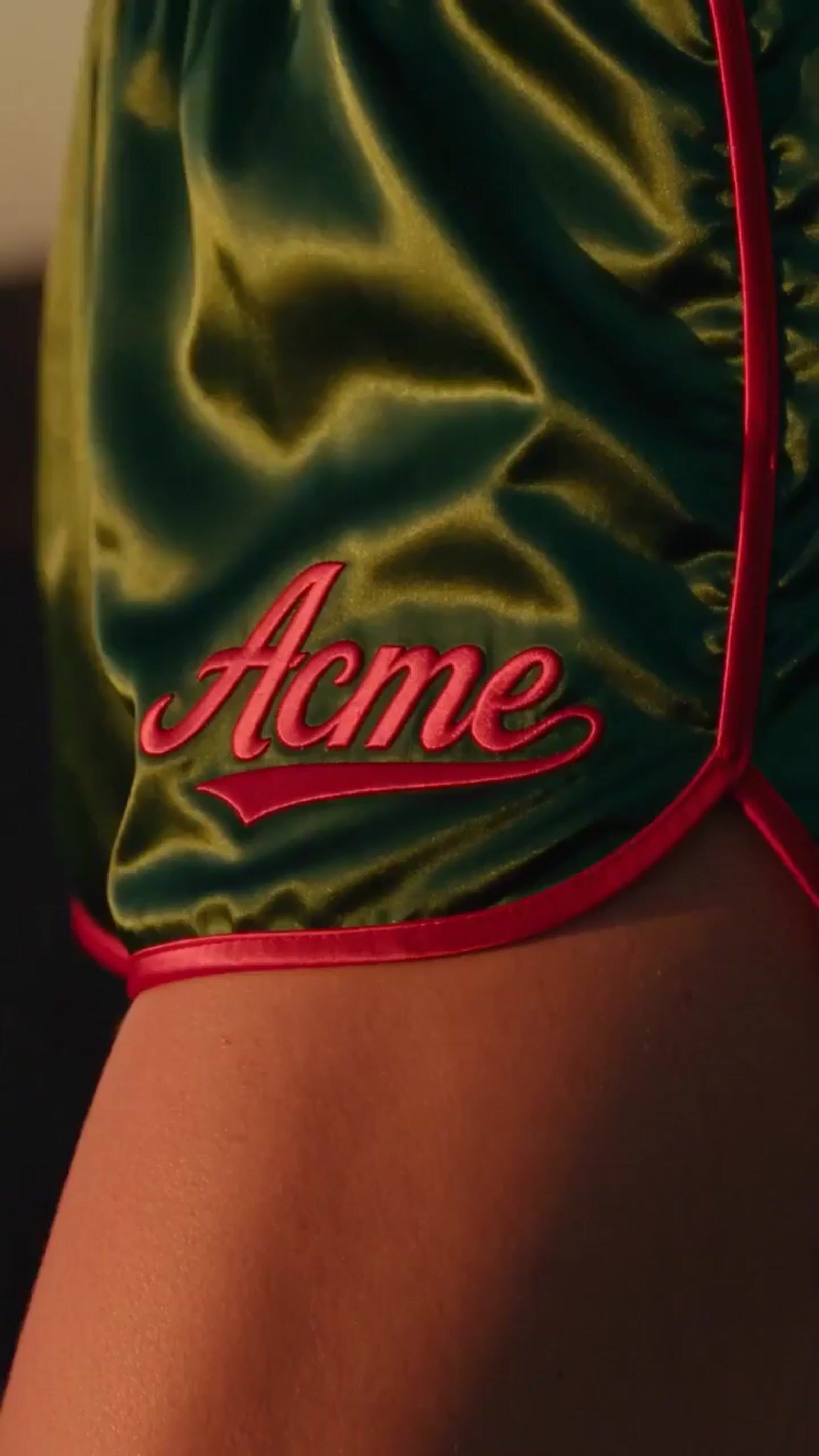 a close up of a person wearing a green and red shorts