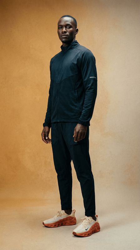 a man standing in front of a brown background