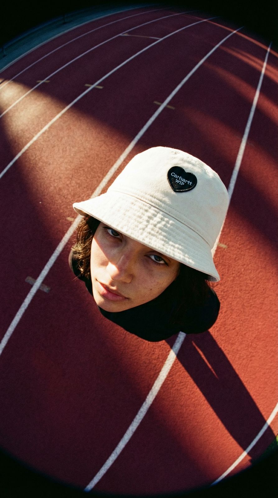 a woman wearing a white hat on top of a track