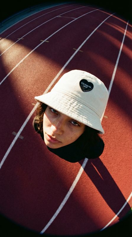 a woman wearing a white hat on top of a track