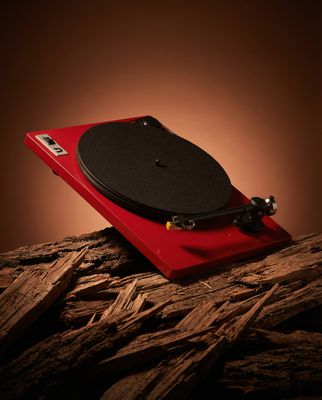 a red turntable sitting on top of a wooden table