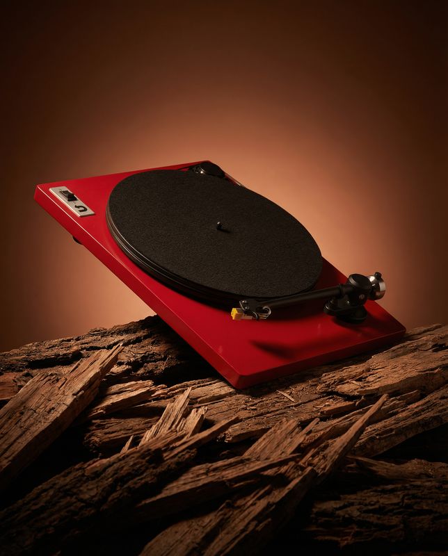 a red turntable sitting on top of a wooden table