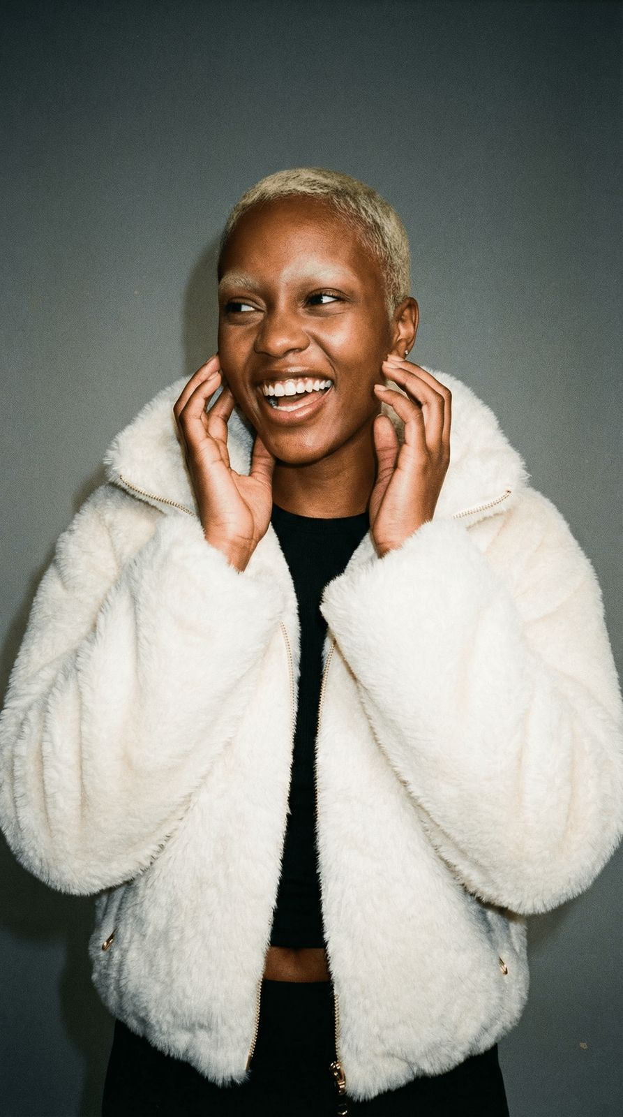 a woman wearing a white jacket and smiling
