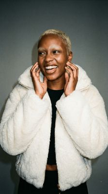 a woman wearing a white jacket and smiling