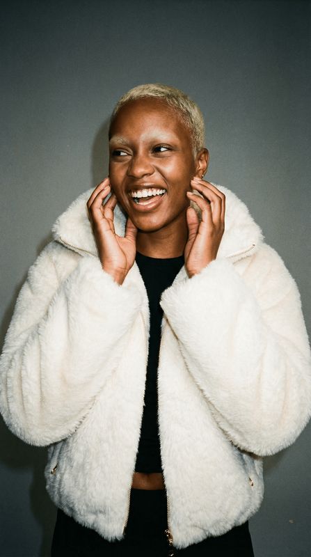 a woman wearing a white jacket and smiling