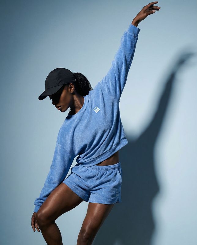 a woman in a blue shirt and shorts doing a dance move