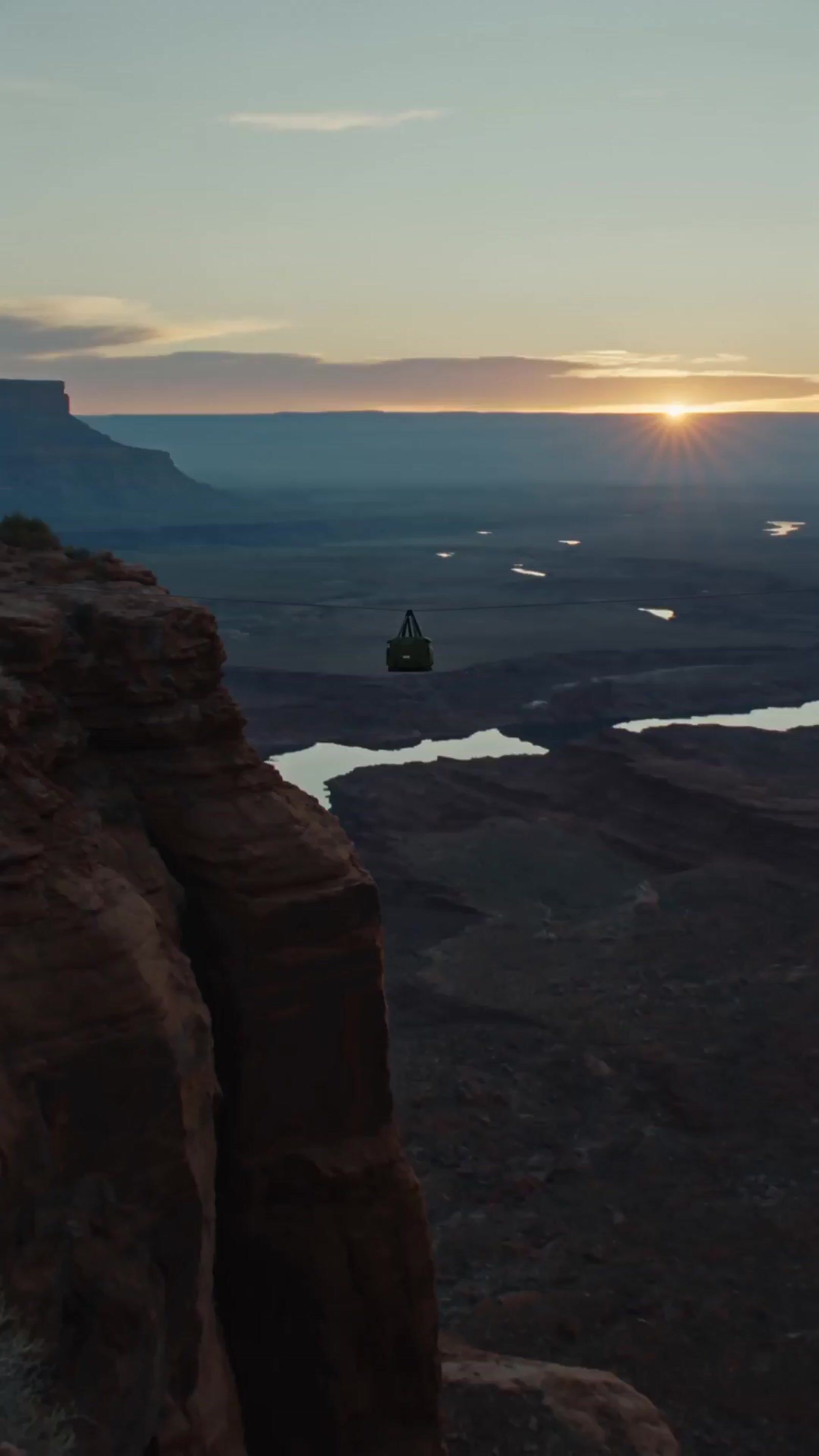 a person standing on a cliff overlooking a lake