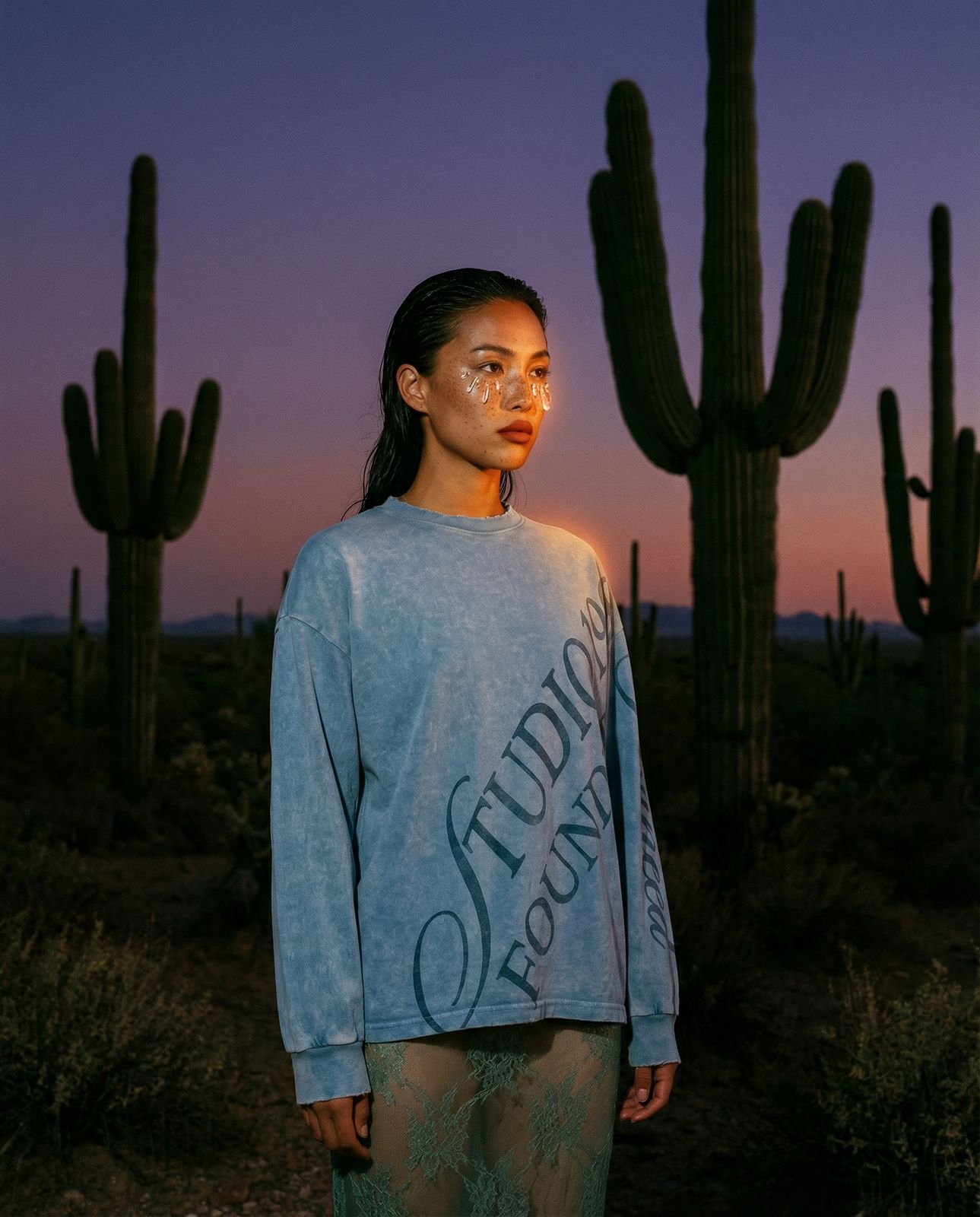 a woman standing in front of a cactus
