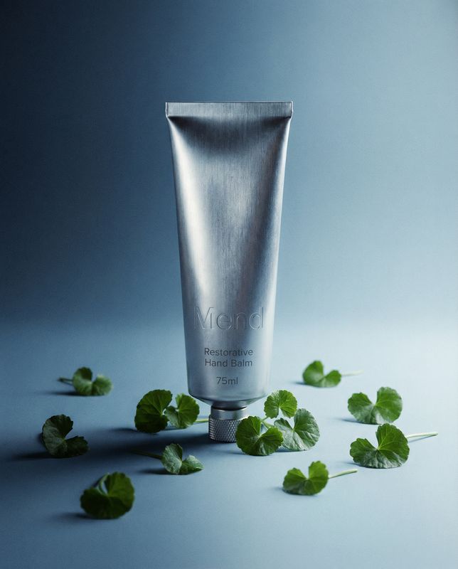 a tube of toothpaste surrounded by leaves