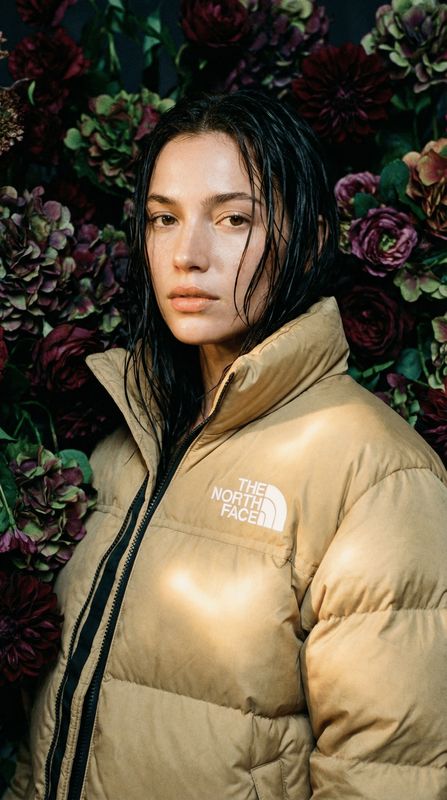 a woman standing in front of a bunch of flowers