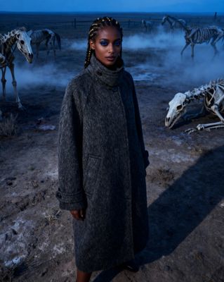 a woman standing in front of a herd of dead animals