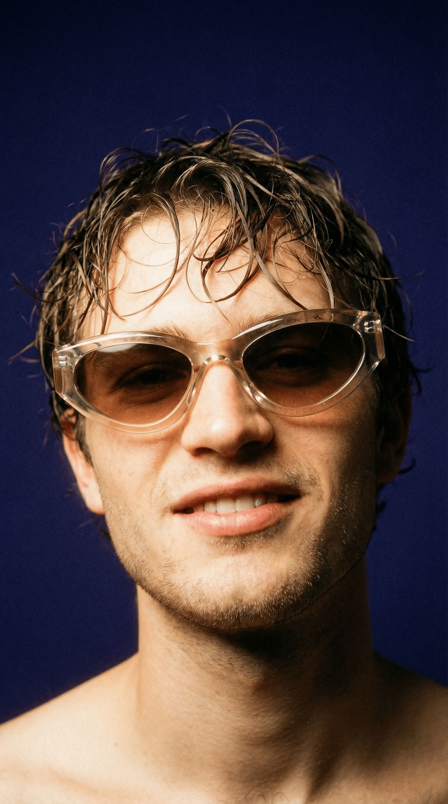 a shirtless man wearing sunglasses and no shirt