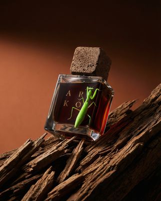 a bottle of perfume sitting on top of a pile of wood