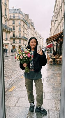 a woman taking a selfie with a bouquet of flowers