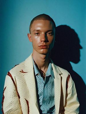 a man in a white jacket and blue shirt