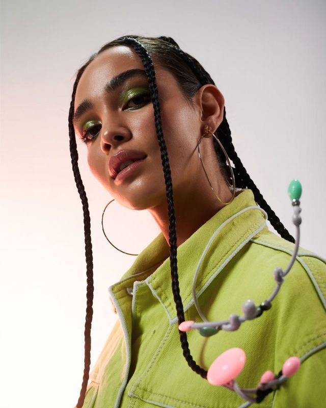 a woman with braids and a green shirt