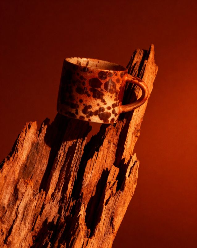 a cup sitting on top of a piece of wood