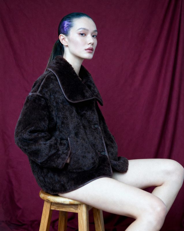 a woman sitting on top of a wooden stool