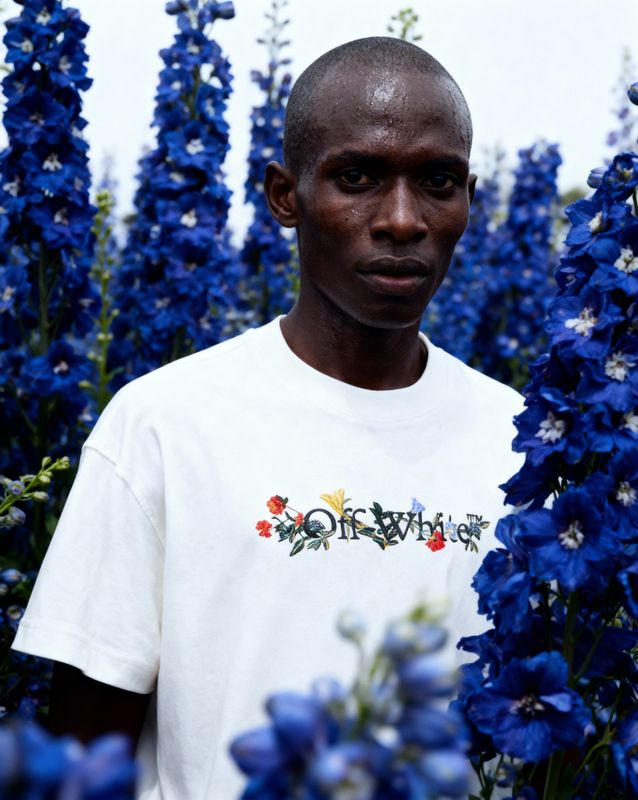 a man standing in a field of blue flowers