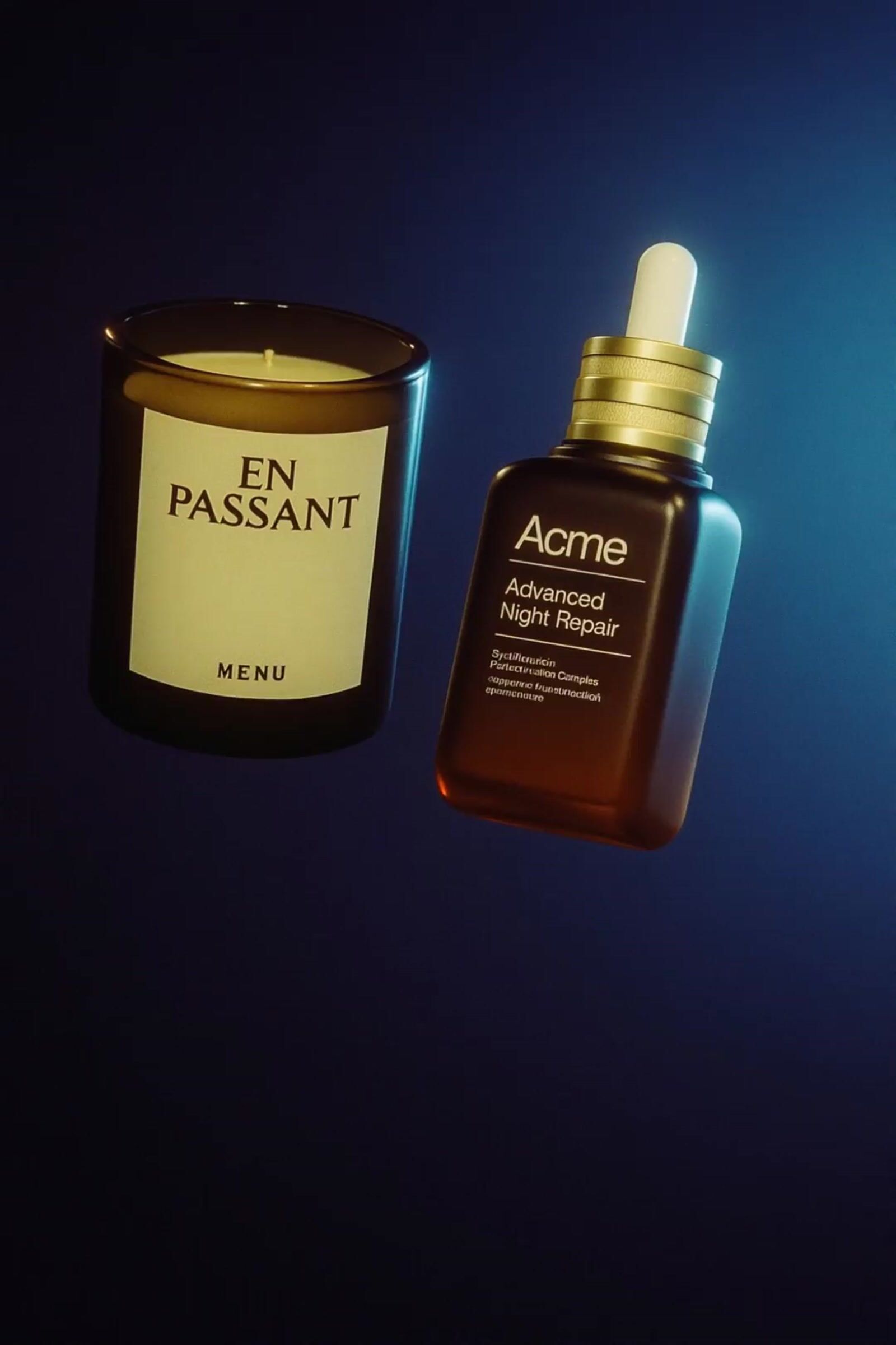 a candle and a bottle of perfume on a table