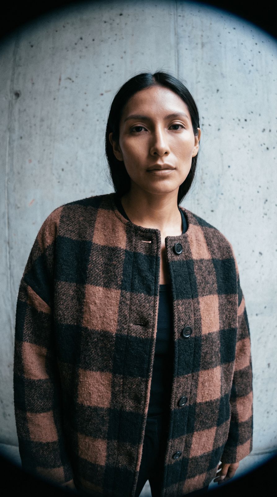 a woman standing in front of a concrete wall