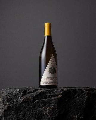 a bottle of wine sitting on top of a rock