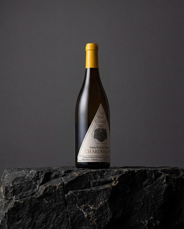 a bottle of wine sitting on top of a rock