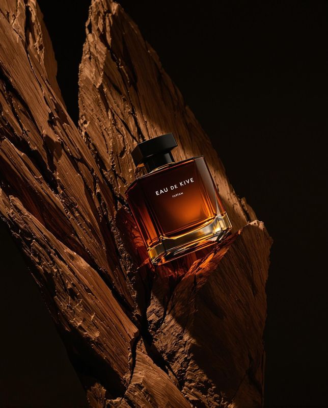 a bottle of perfume sitting on top of a rock