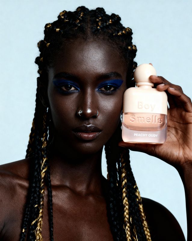 a woman holding a bottle of makeup next to her face
