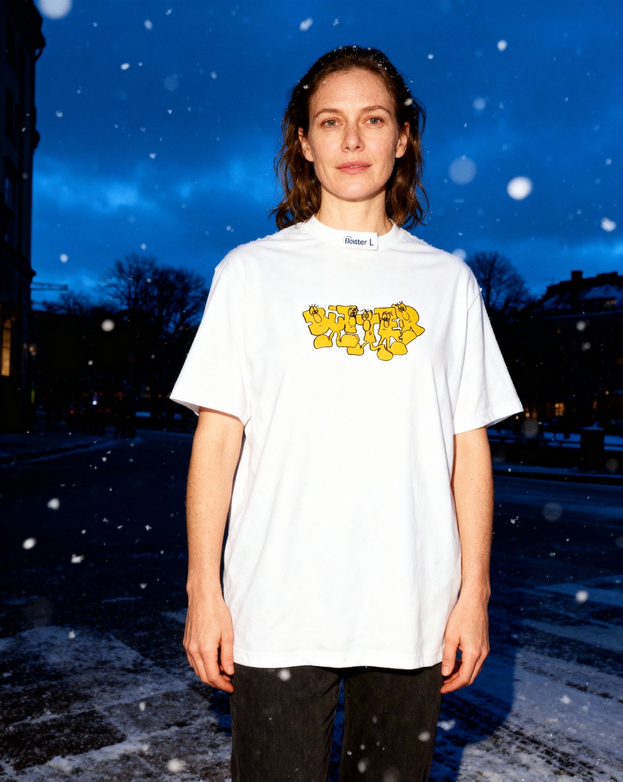 a woman standing in the snow wearing a white shirt