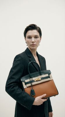 a woman holding a brown and black purse