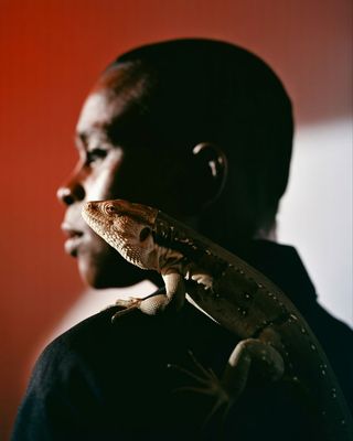 a man with a lizard on his shoulder