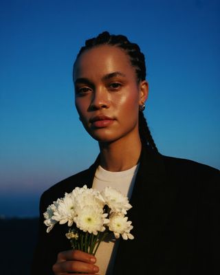 a woman holding a bouquet of white flowers