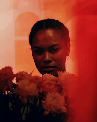 a woman holding a bunch of flowers in her hands