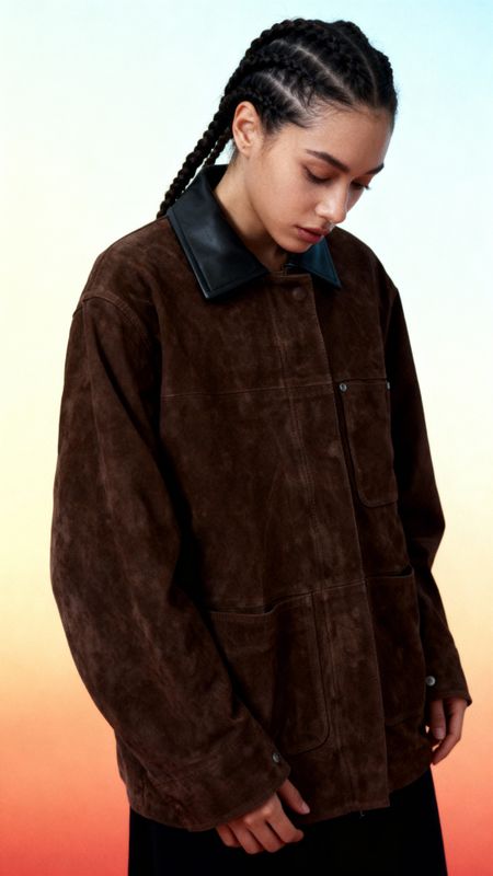 a woman with braids wearing a brown jacket