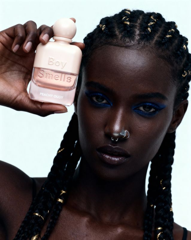 a woman with a nose ring holding a bottle of nail polish