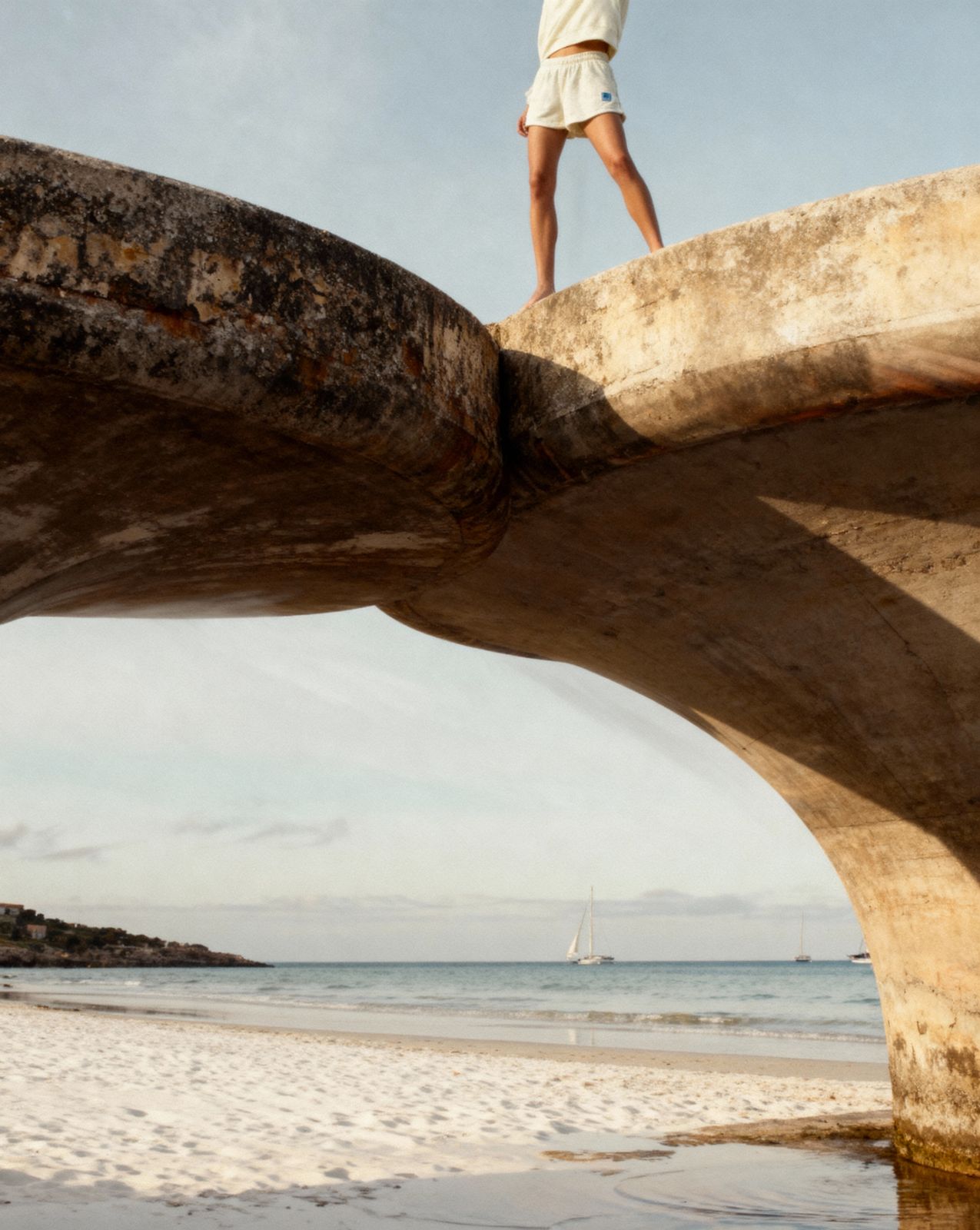 a person standing on a bridge over a beach
