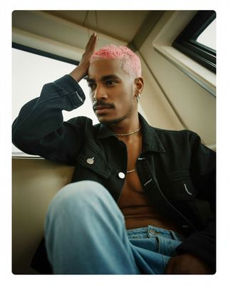 a man with pink hair sitting in a car