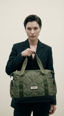 a woman holding a green duffel bag