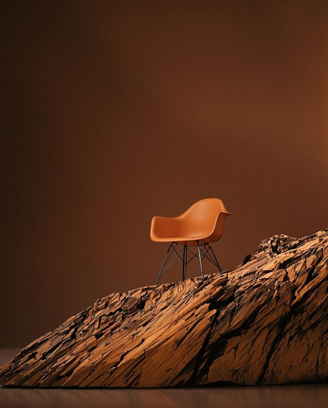 an orange chair sitting on top of a rock