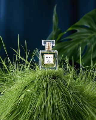 a bottle of perfume sitting on top of a green plant