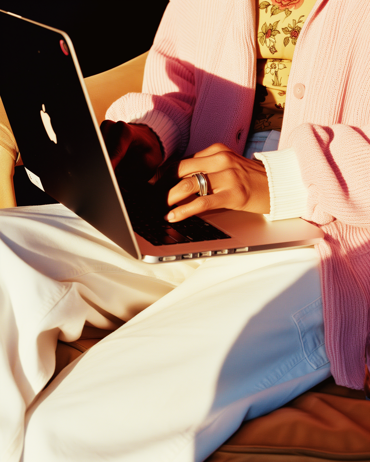 a woman sitting on a bed using a laptop computer