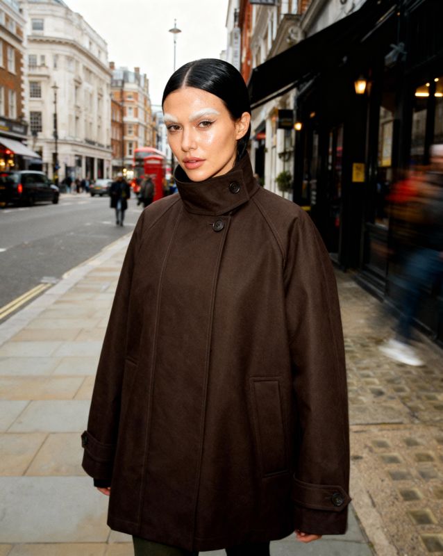 a woman standing on a sidewalk next to a building