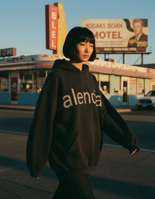 a woman walking down the street in front of a motel